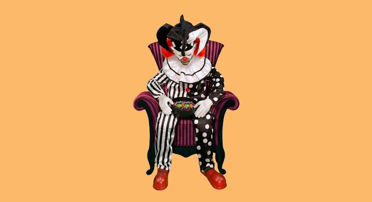 Spirit Sitting Scare Clown in a red and black striped armchair holding a bowl of candy in his lap