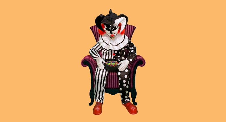 Spirit Sitting Scare Clown in a red and black striped armchair holding a bowl of candy in his lap 