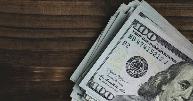 100 dollar bills are stacked on a table