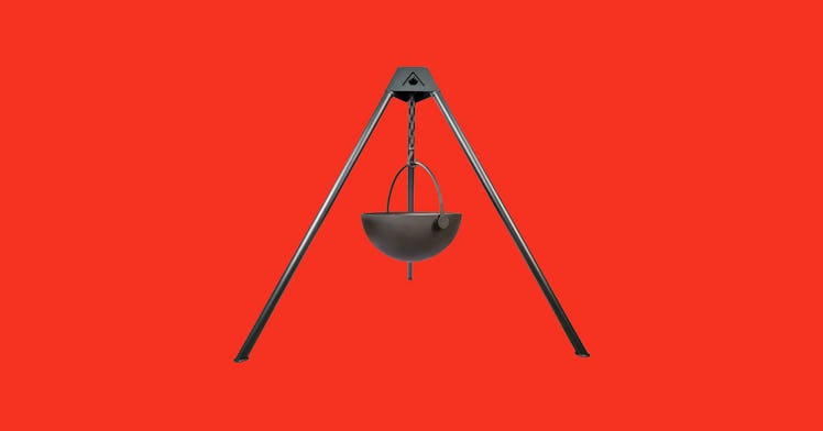 A wood-burning fire pit against a red backdrop