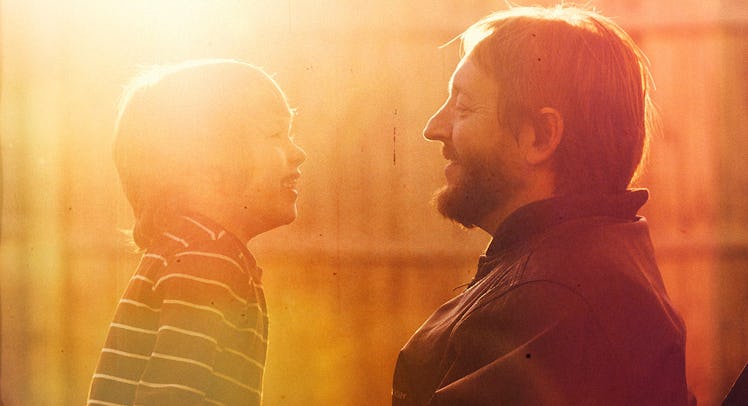 A father and his son smiling at each other and talking