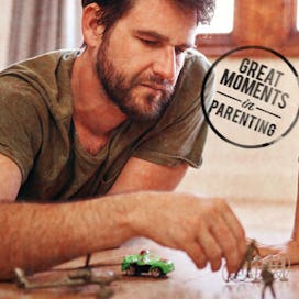 Father and son playing with action figures on floor