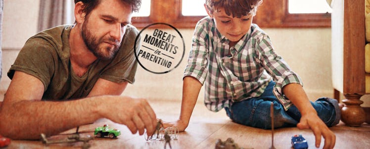 Father and son playing with action figures on floor
