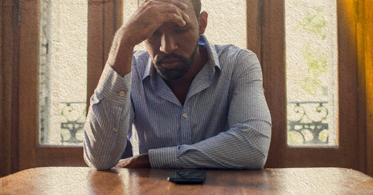 A man sitting at a desk with his hand on his head in disappointment