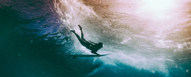 A new mom diving with a surf board under the water