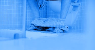 blue edit of a man sitting on a toilet with his pants around his ankles