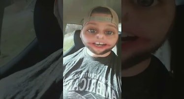 A dad taking a selfie with a baby filter of his face while sitting in a car