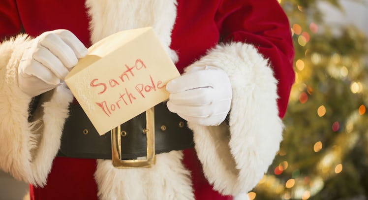 Santa holding an envelope with "Santa North Pole" on it