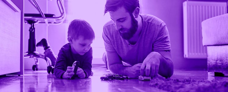 A dad playing cars with his son on the floor