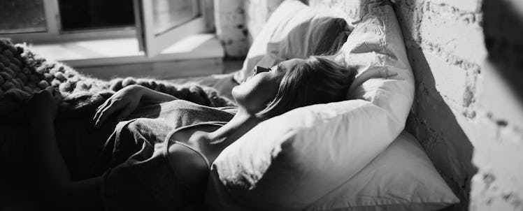 A woman sleeping in her bed after experiencing pregnancy loss