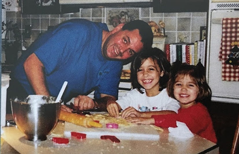 A dad preparing a meal with his two daughters