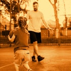 A dad playing basketball with his daughter