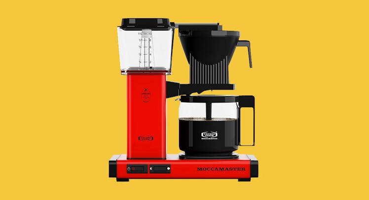 The Technivorm Moccamaster 59616 KBG Coffee Brewer in red on a yellow background