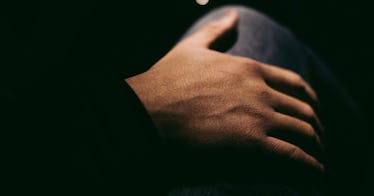 closeup of a man's hand surrounded by shadow