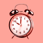 an analog clock on a pink background