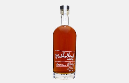 A transparent bottle of Mulholland American Whiskey