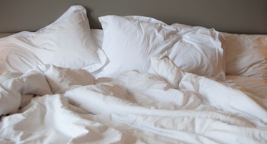 White pillows and sheets tussled across a bed frame