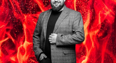 bearded fat guy in black sweater and blazer on background with flames