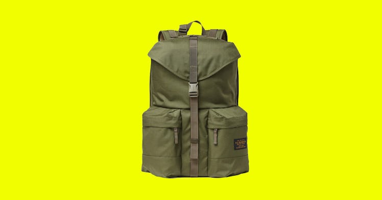 Green backpack for men with two side pockets on the bottom and a clip for closing down the middle.