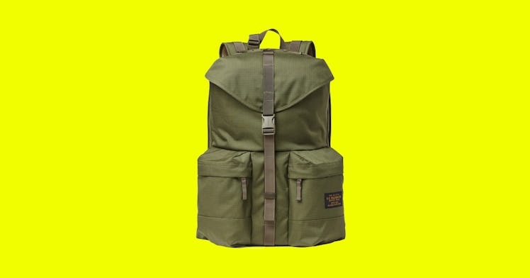 Green backpack for men with two side pockets on the bottom and a clip for closing down the middle. 