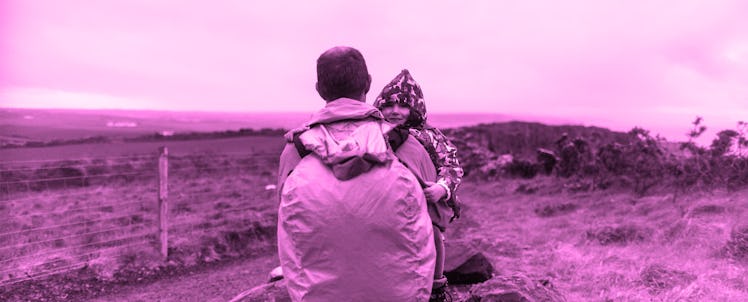 A dad carrying his child in the wilderness