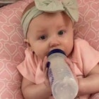 A little baby drinking milk from a bottle