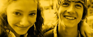 A young couple with their arms around each other smiling and looking at the camera