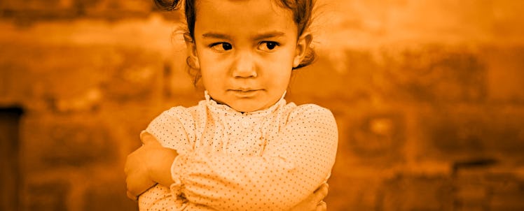 A little angry girl with crossed arms