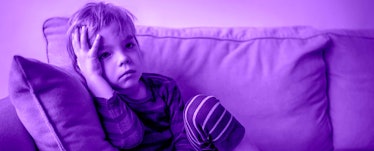 An autistic little boy sitting alone on a couch