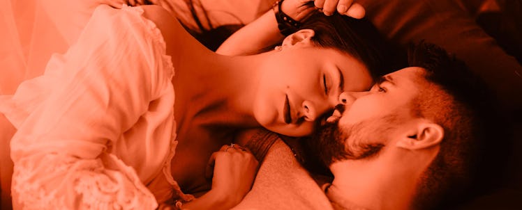 A husband and a wife lying while hugging in their bed