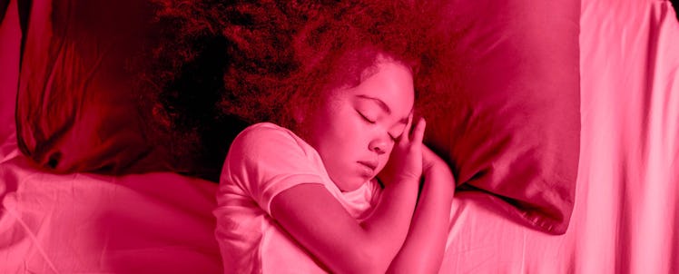 A little curly-haired girl sleeping on her side