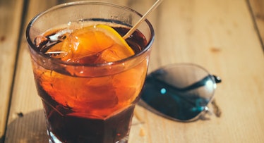 photo of refreshing bourbon cocktail set beside sunglasses