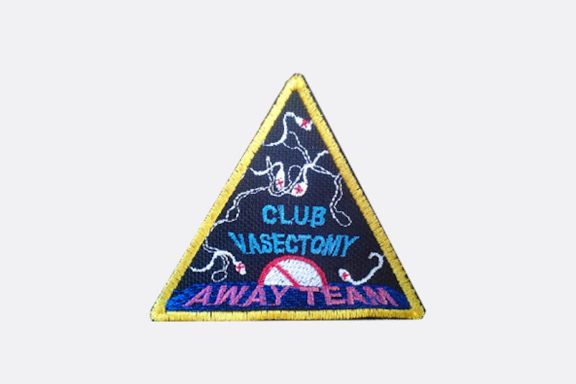 A triangular Club Vasectomy Embroidered Patch with a golden frame and light blue writing