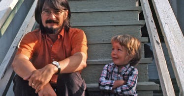 A dad and his son sitting on white wooden stairs