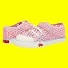 A pink pair of shoes for toddlers in front of a yellow background.