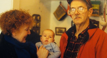 Two baby boomer grandparents holding their grandchild