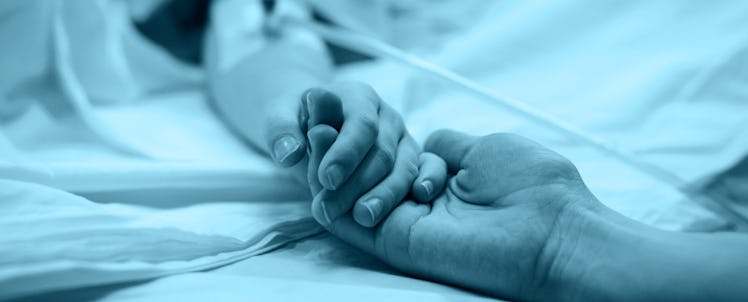 A husband holding his wife's hand after she had a miscarriage