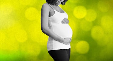 pregnant woman holding her baby bump with fart green backdrop