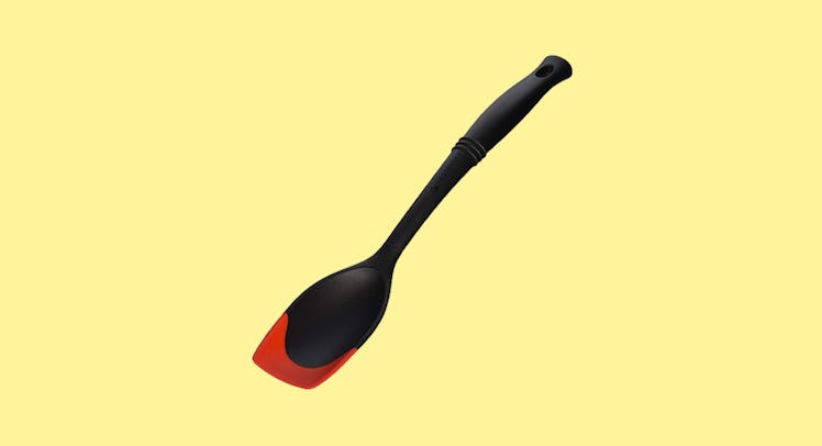 The Le Creuset of America Revolution Bi-Material Saute Spoon on a yellow background