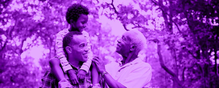 Grandpa, dad, and child standing together in nature
