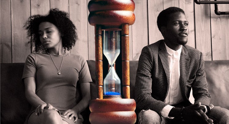 A couple sitting on the couch at marriage counseling with an hourglass between them
