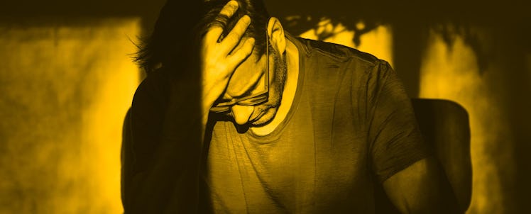 A man recovering from drug addiction sitting in a chair with his head in his hand