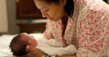 a mother cradles and gazes at her unique baby boy in the middle of her arms