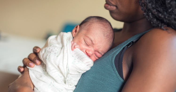 a sleeping baby being held by an adult, depicting gender-neutral baby names