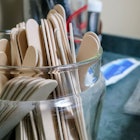 A glass jar filled with wooden spatula's at a doctor's office