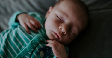 closeup of a unique baby boy sleeping in green and white striped pajamas