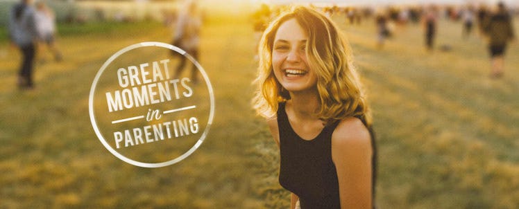 A woman in a black top standing in an open field, "great moments in parenting" logo next to her