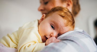 irish newborn baby with red hair being held by mother