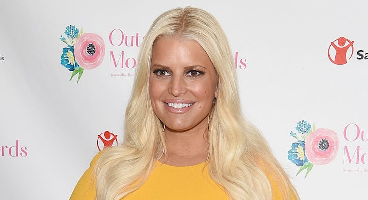 Jessica Simpson smiling for a photo on a red carpet 