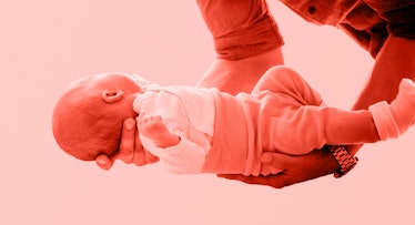 red tinted edit of dads arms holding newborn baby with moro reflex
